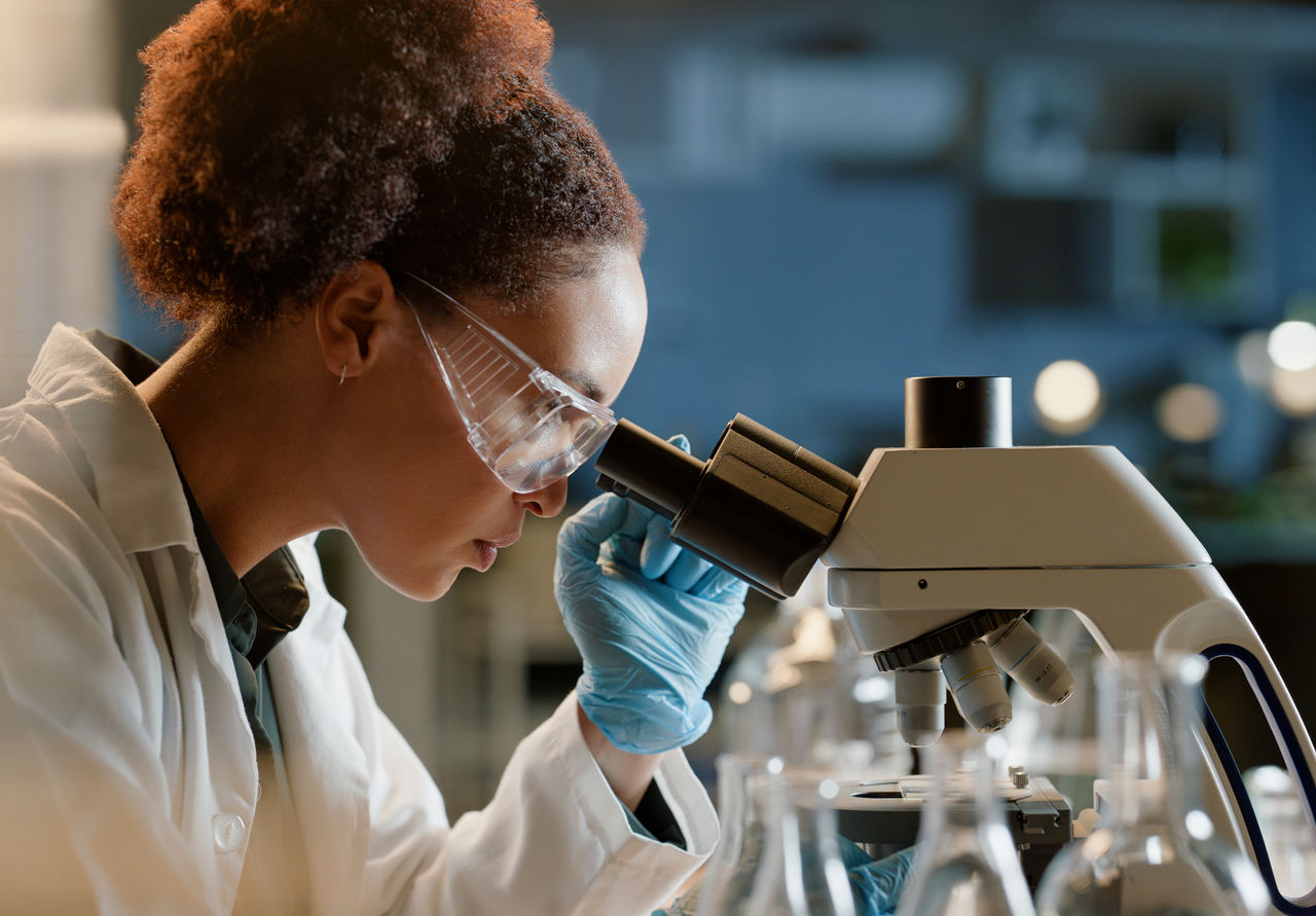 2149039463 A scientist in a research lab examining samples under a microscope, indicating science-based innovation at Danone.